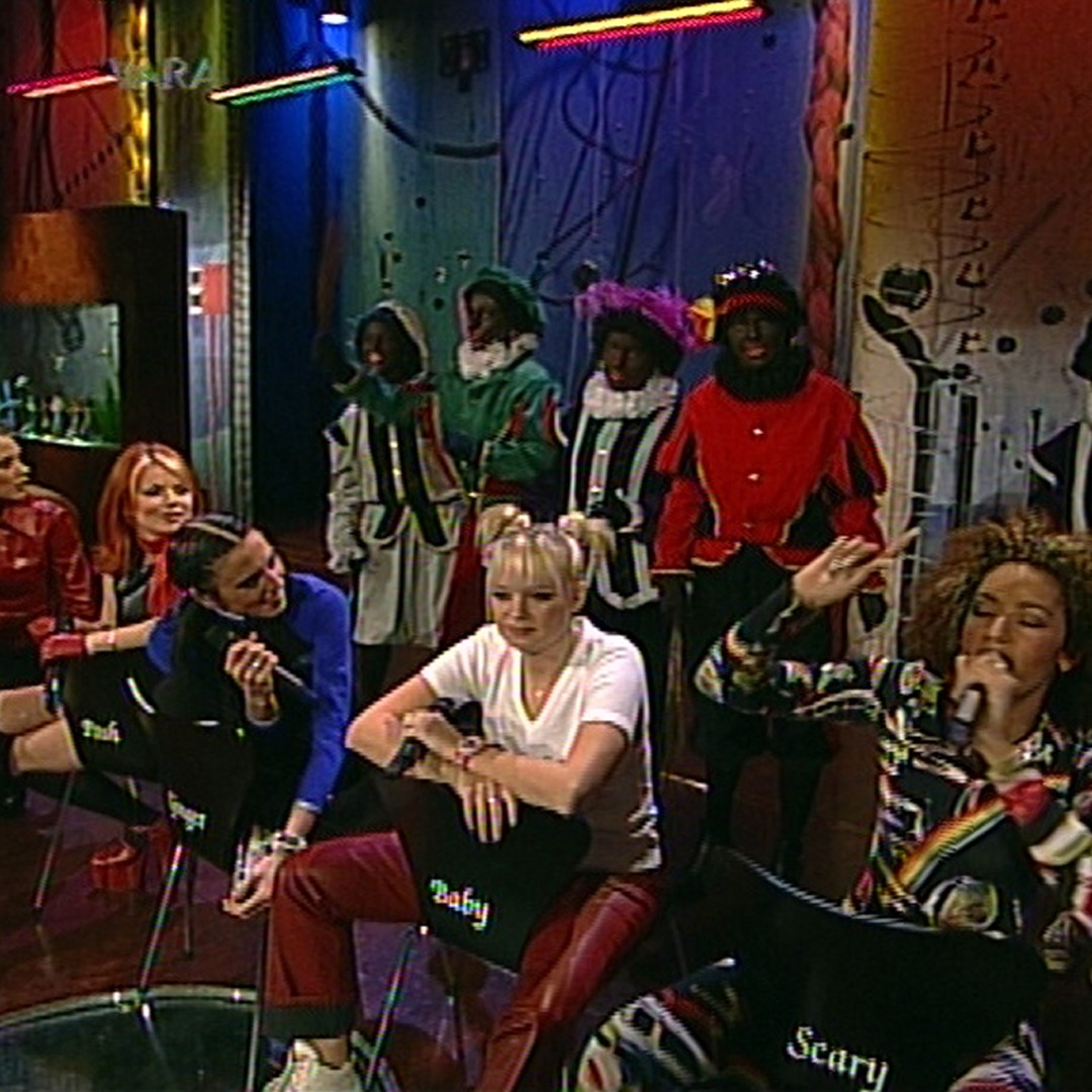 Decoratief: screenshot van de Spice Girls in het programma van Paul de Leeuw met op de achtergrond een rij van 'Zwarte Pieten'