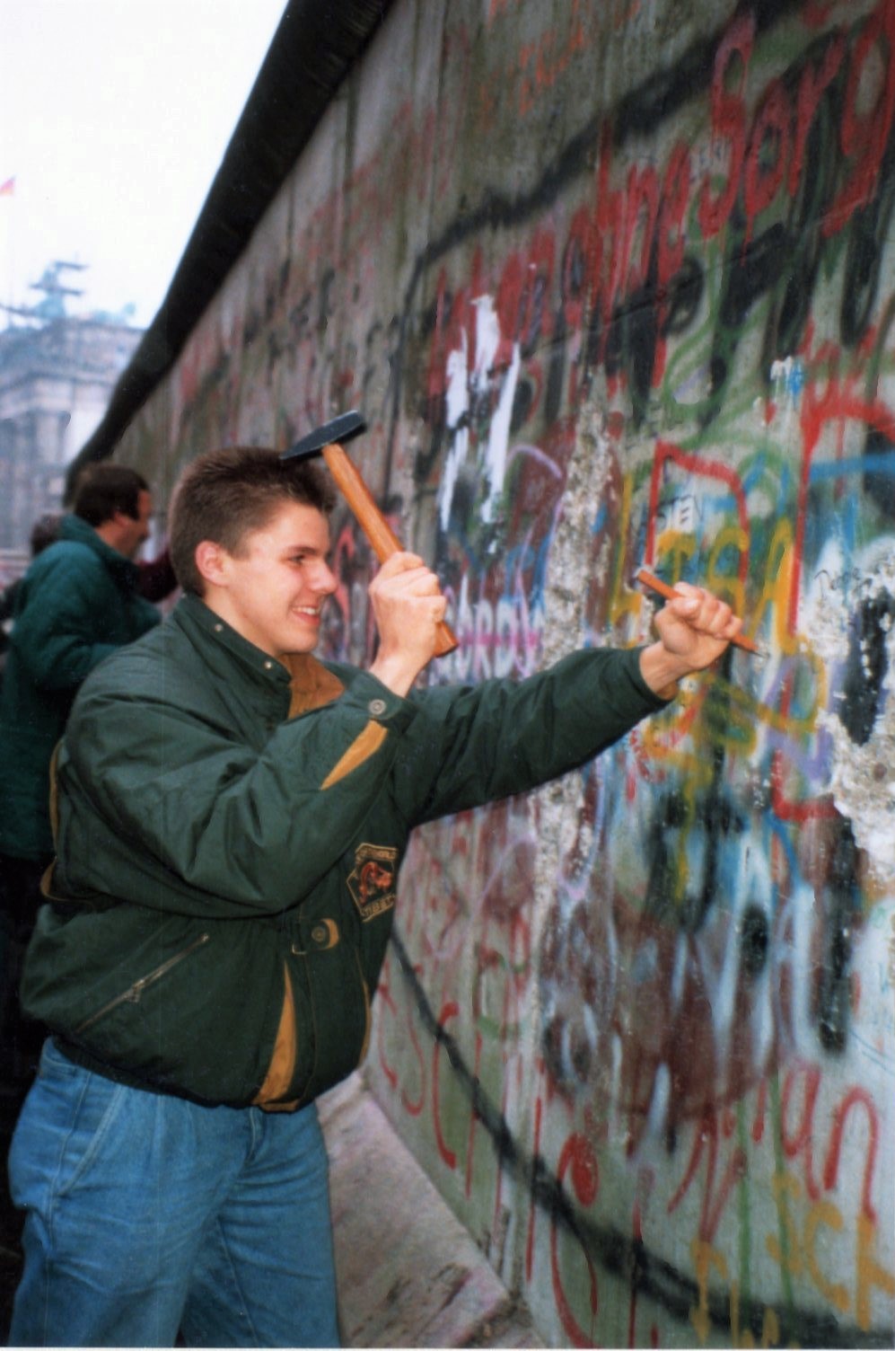 Een man vernield de Berlijnse muur